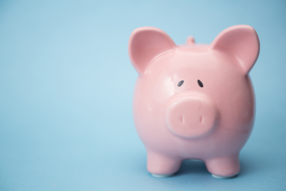 Piggy bank with copy space on blue background-1