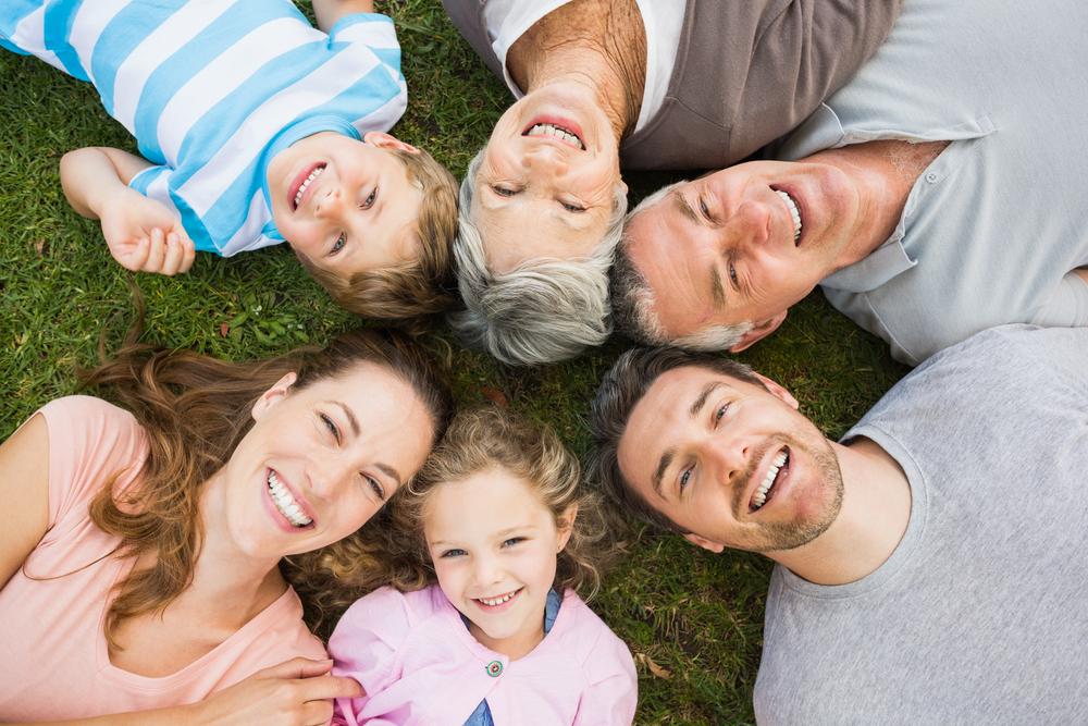 High angle portrait of an extended family lying in circle at the park